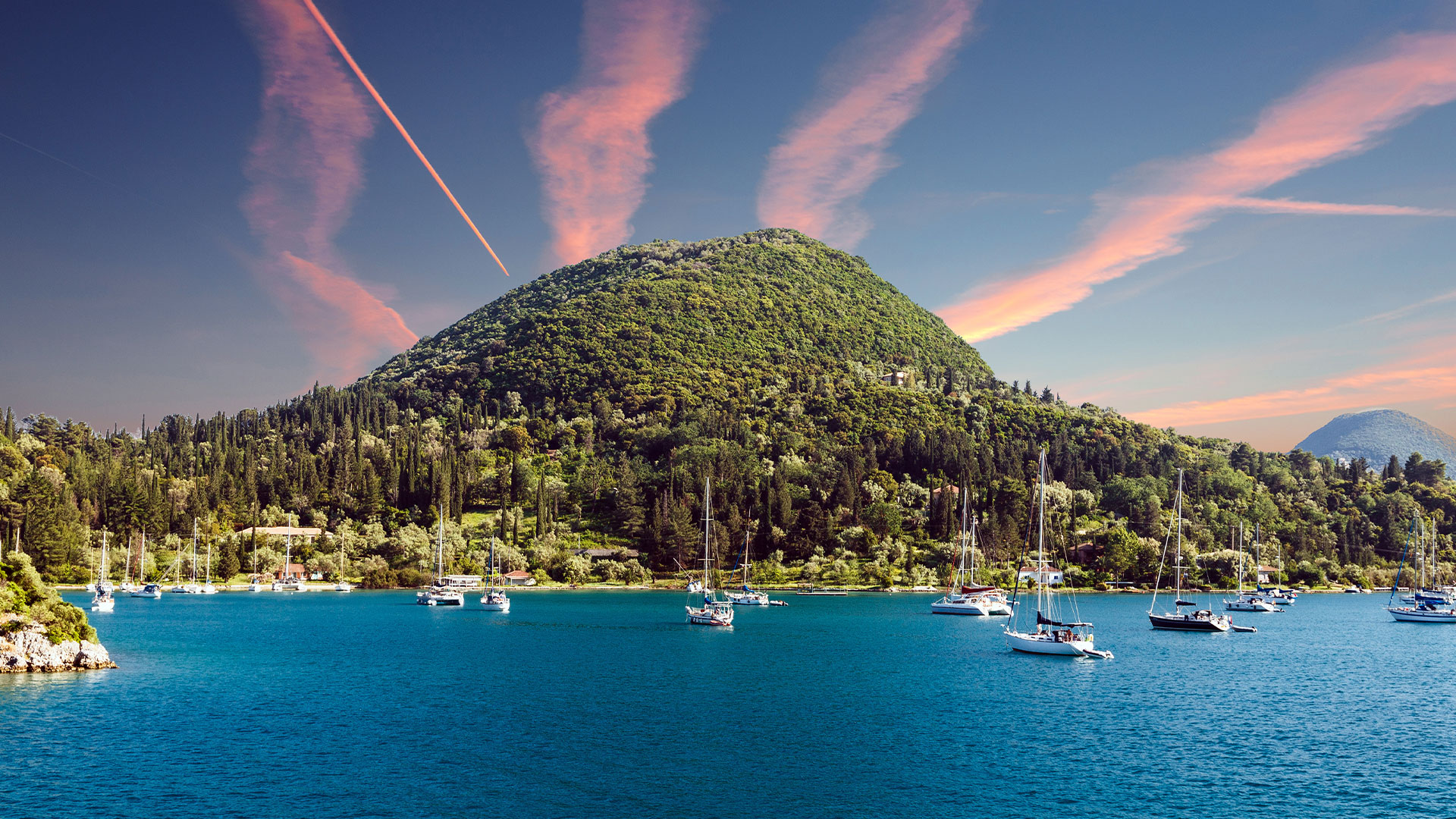 Idyllic Lefkas bay with anchored yachts, highlighting the island's real estate investment opportunities.