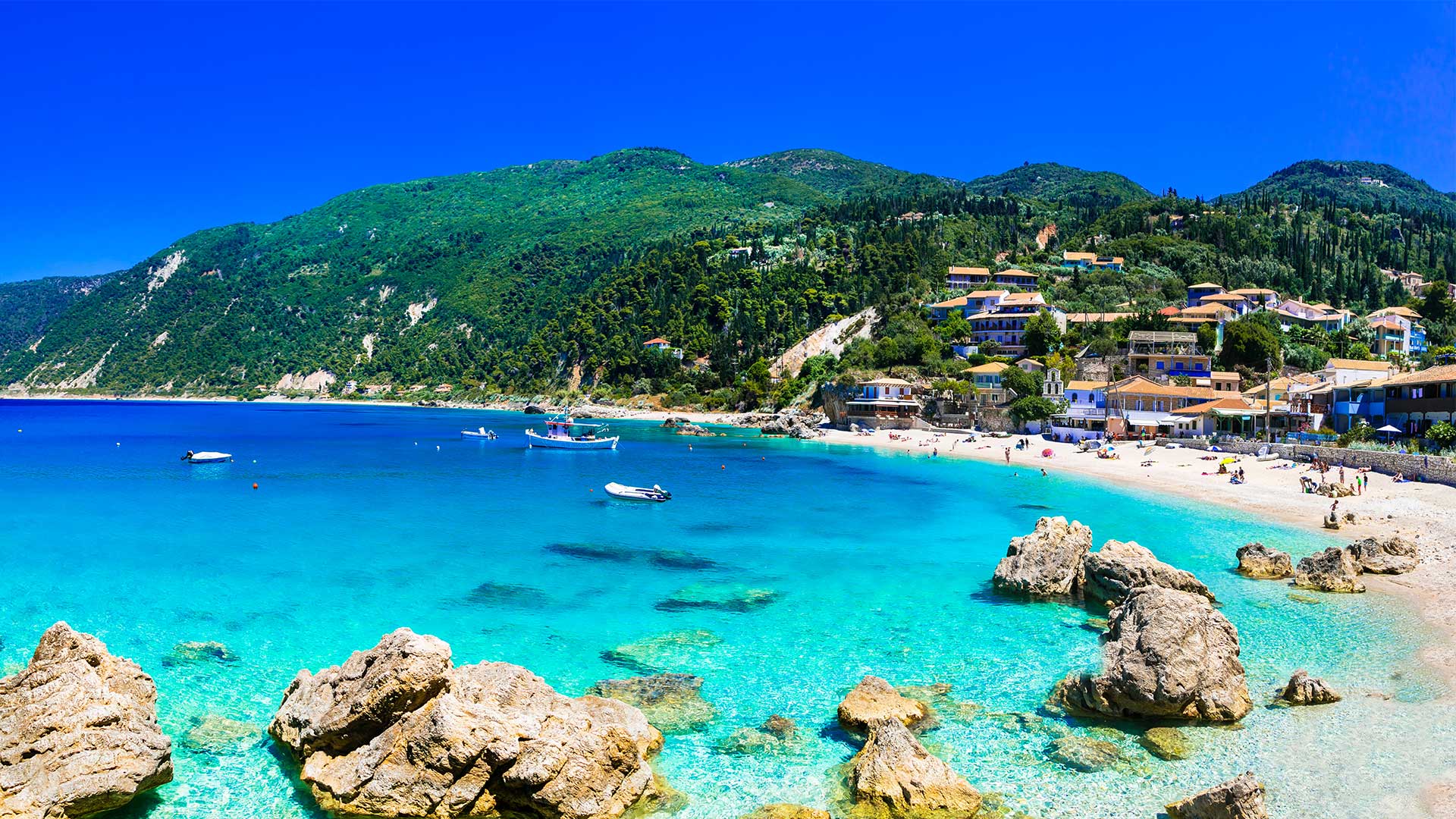 Agios Nikitas beach in Lefkada, clear turquoise waters with beachfront properties.