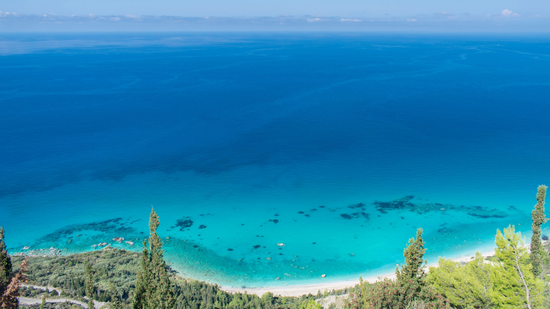 Overlooking view of the turquoise waters and verdant terrain of Lefkada Kalamitsi, illustrating the prime real estate and investment opportunities in the region.