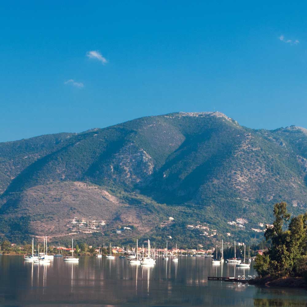 Serene Lefkada Geni bay with moored yachts, showcasing prime real estate opportunities.