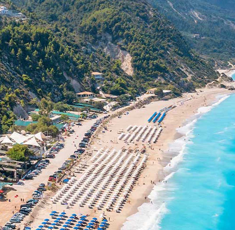 Kathisma Beach in Lefkada, lined with sunbeds, a hotspot for real estate investment.