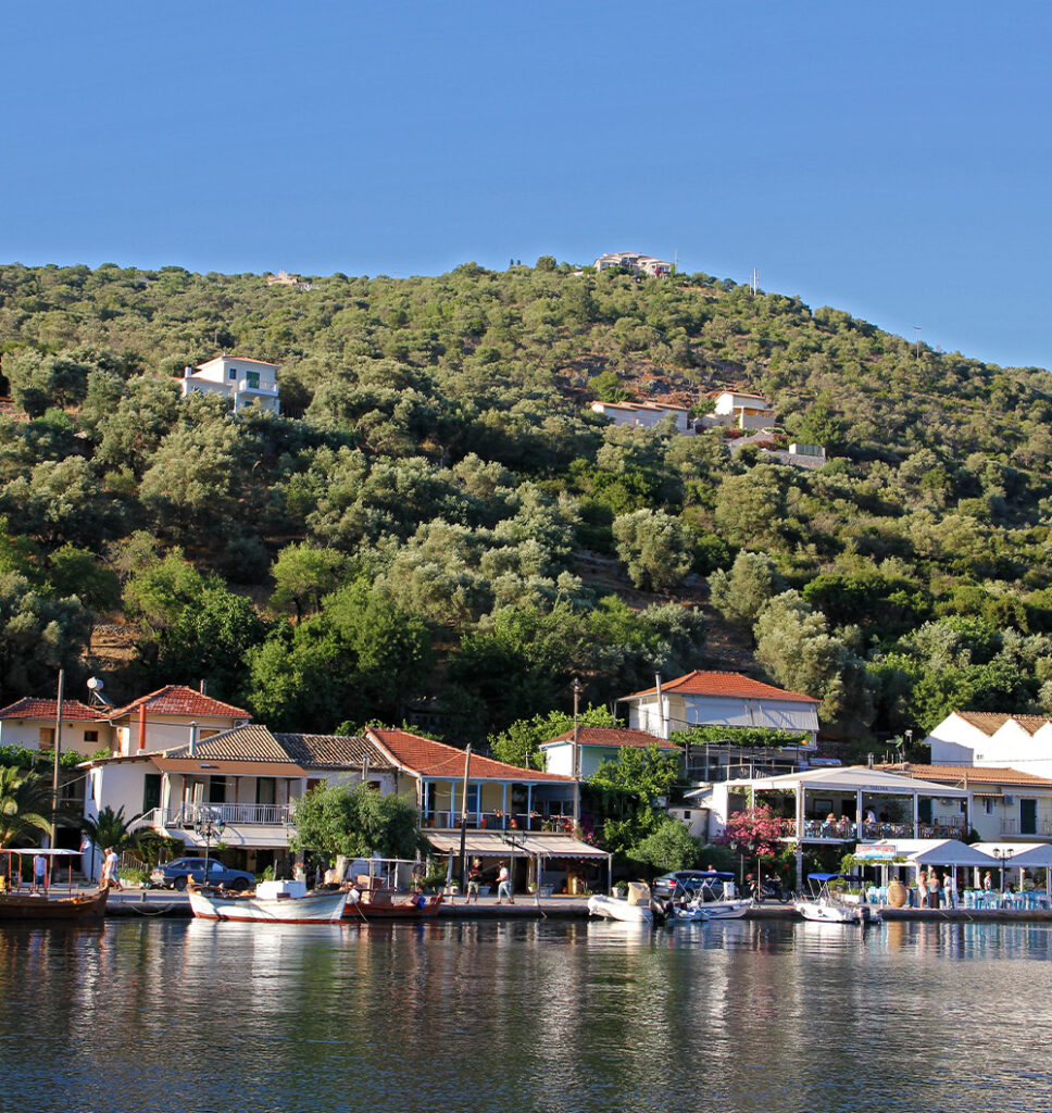 Quaint homes and lush greenery line Syvota Bay in Lefkada, a prime location for real estate investment.